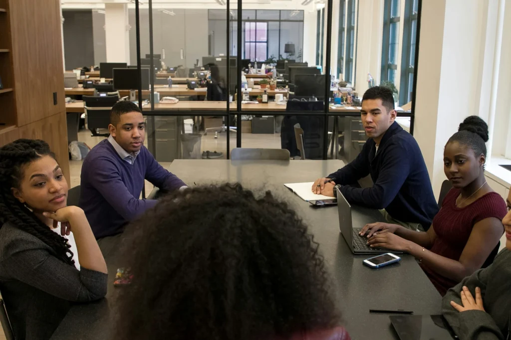 A group of colleagues seated around a conference table in an office.